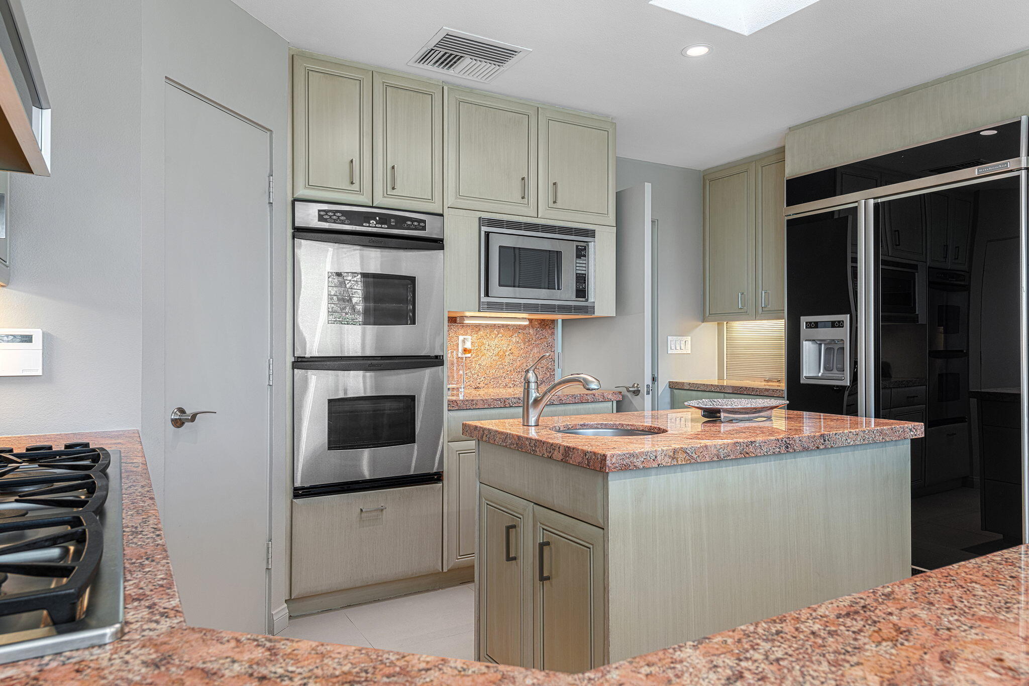 10 Creekside Drive Rancho Mirage, CA 92270 - Photo 17 of 32 a kitchen with stainless steel appliances granite countertop a stove sink and microwave