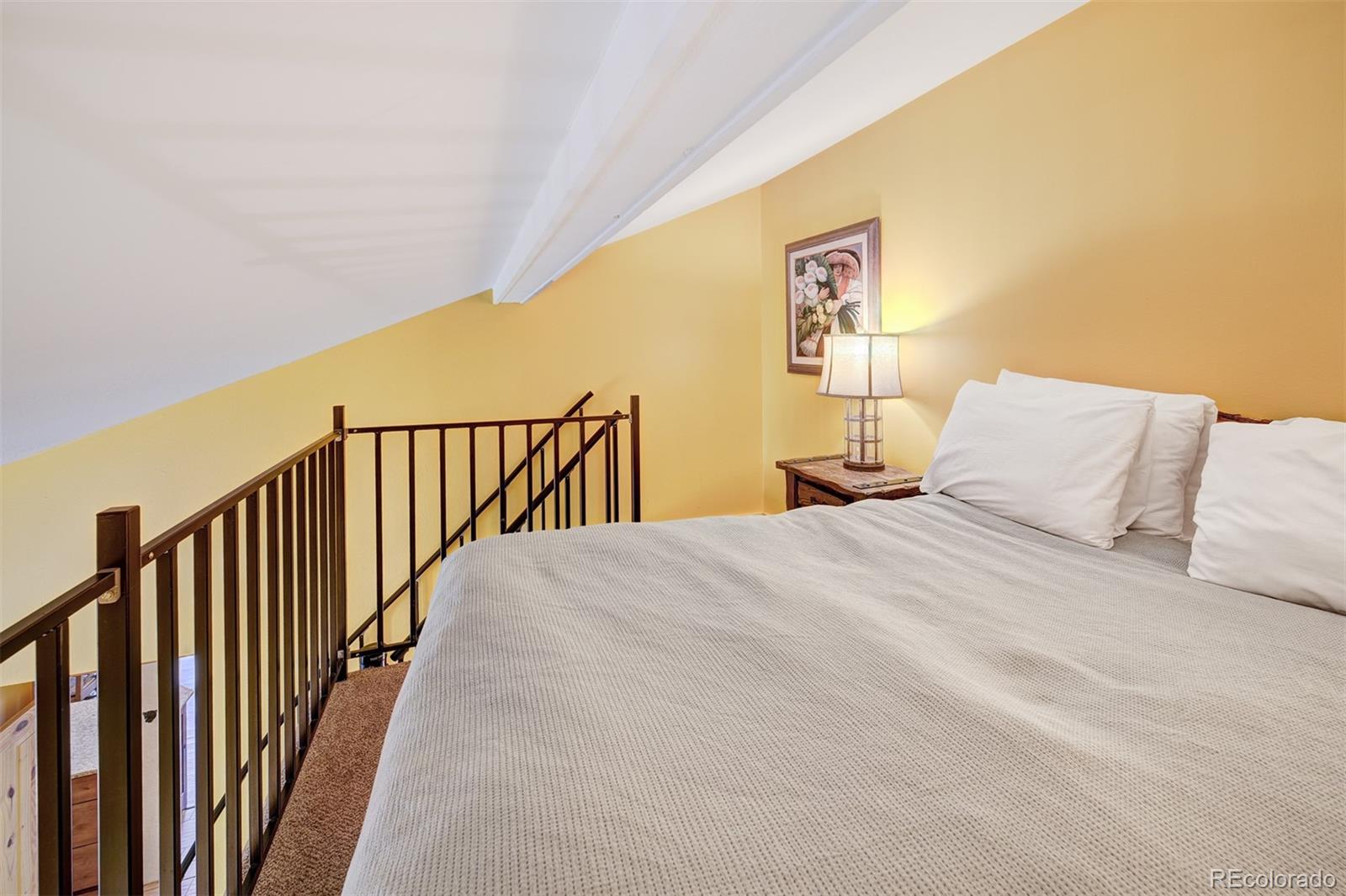 760 Columbine Road, Unit B6 Breckenridge, CO 80424 - Photo 18 of 39 a bedroom with a bed and wooden floor