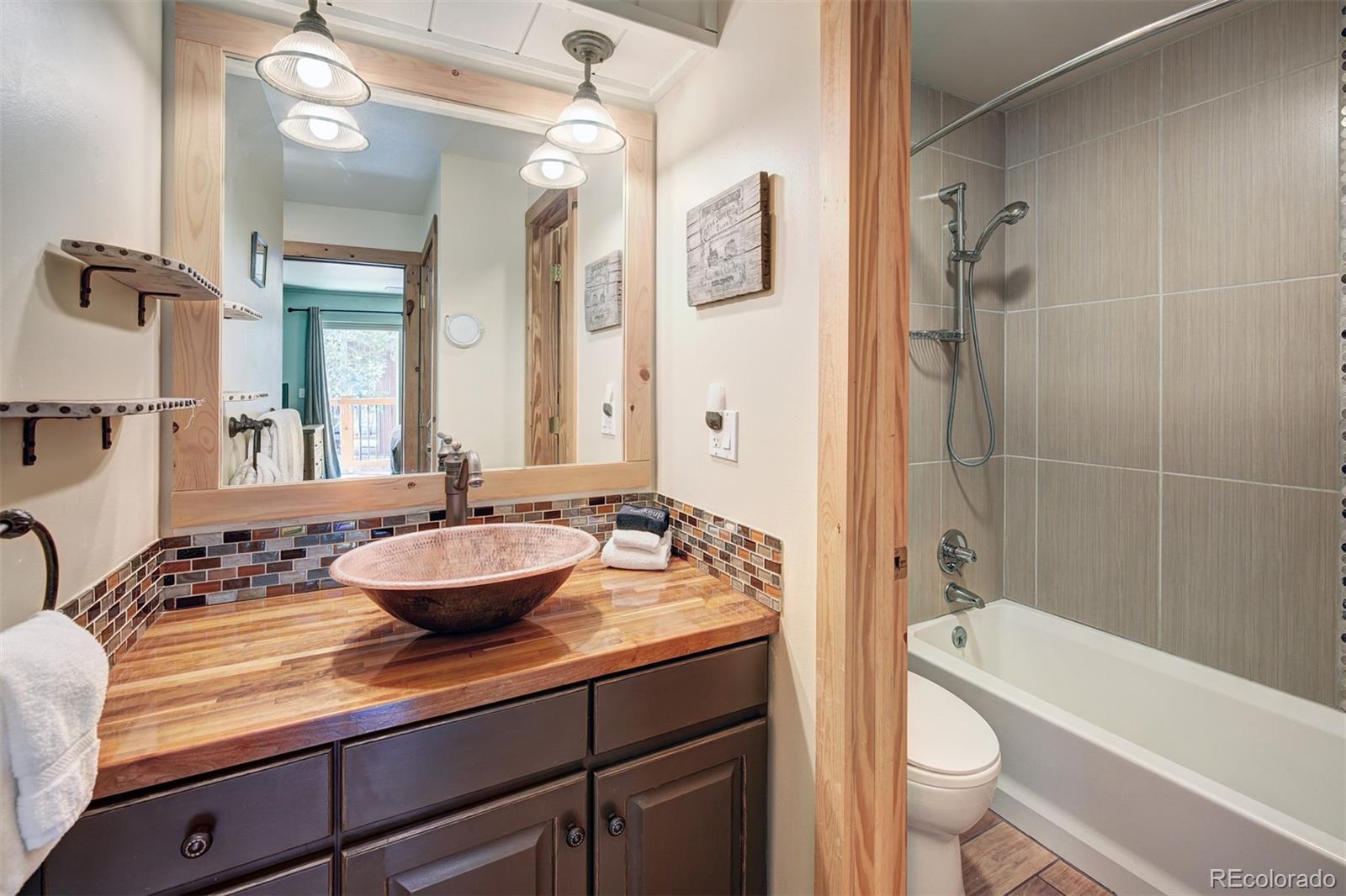 760 Columbine Road, Unit B6 Breckenridge, CO 80424 - Photo 22 of 39 a bathroom with a granite countertop sink a toilet a mirror a bathtub and shower