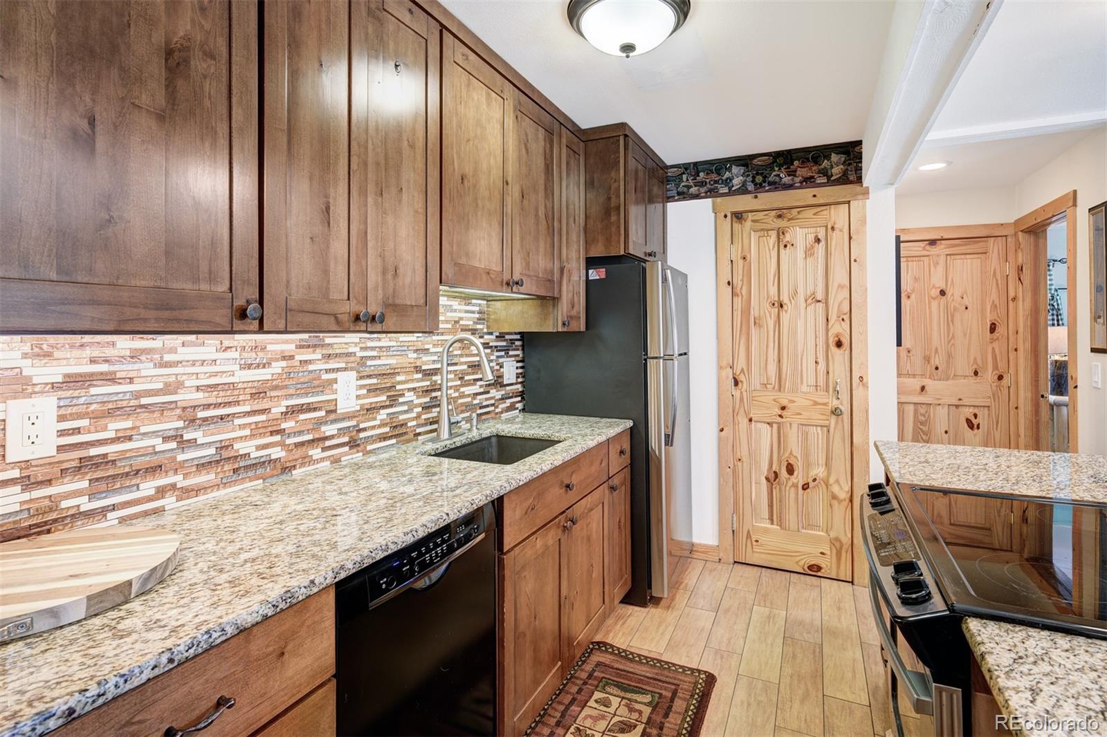 760 Columbine Road, Unit B6 Breckenridge, CO 80424 - Photo 9 of 39 a kitchen with stainless steel appliances granite countertop a sink a stove and a refrigerator