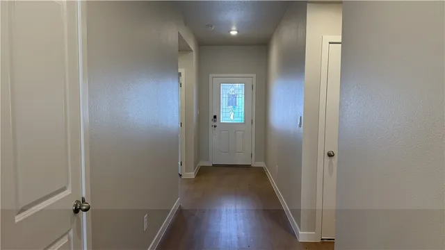 a view of a hallway with wooden floor
