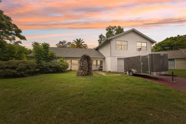 a view of a house with a yard and sitting area