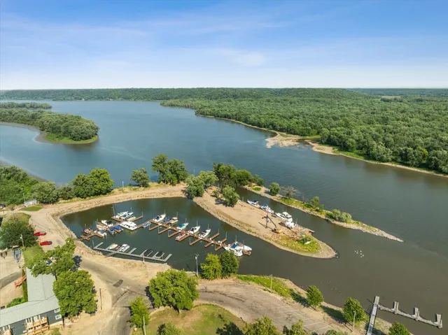 an aerial view of residential houses with outdoor space and lake view