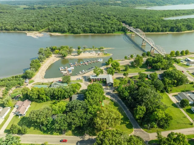 an aerial view of a house with a yard and lake view