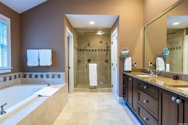 a spacious bathroom with a bathtub sink and mirror