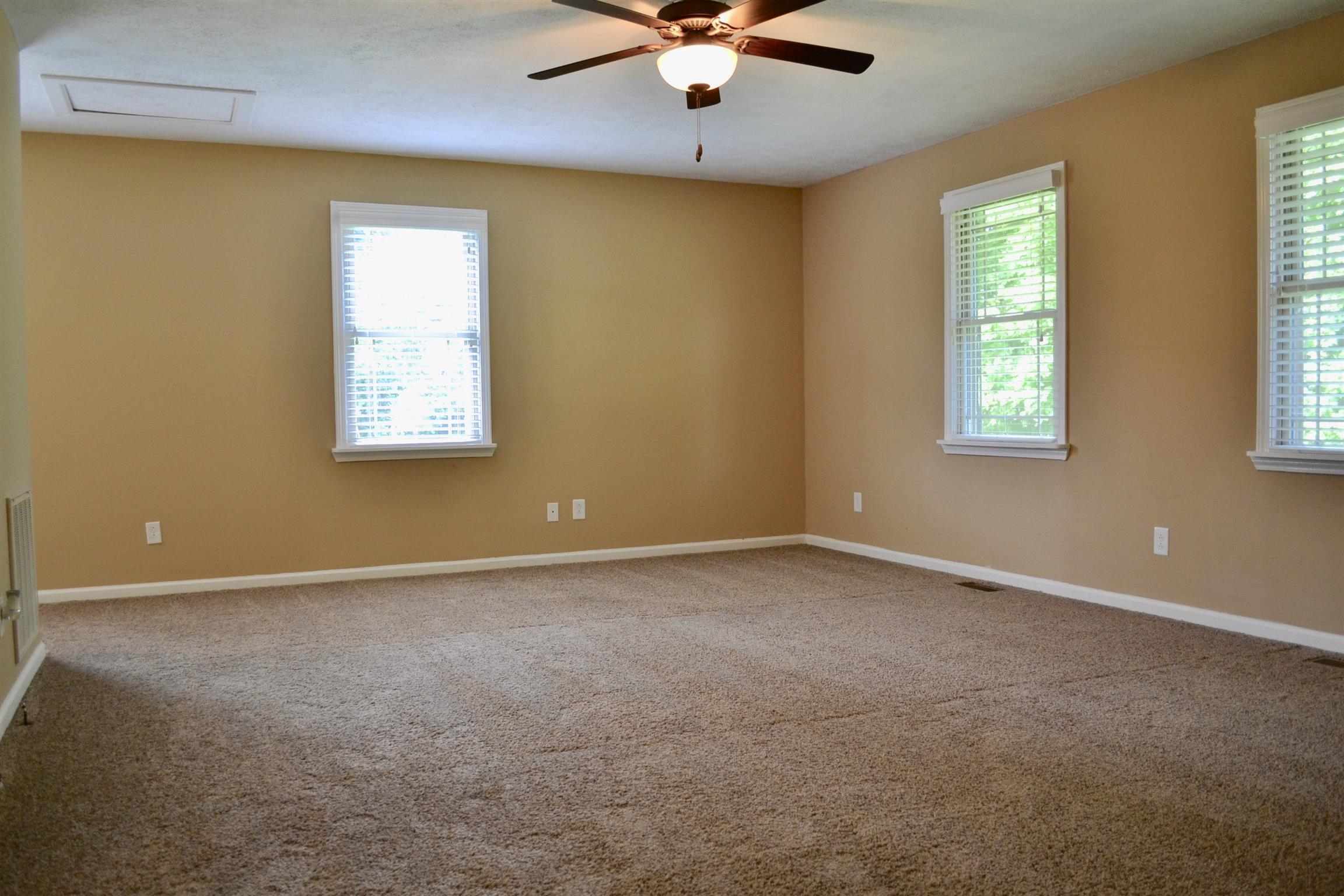 5089 Trough Springs Road Adams, TN 37010 - Photo 8 of 30 an empty room with windows and chandelier fan
