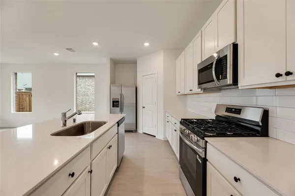a kitchen with stainless steel appliances granite countertop a sink a microwave and cabinets
