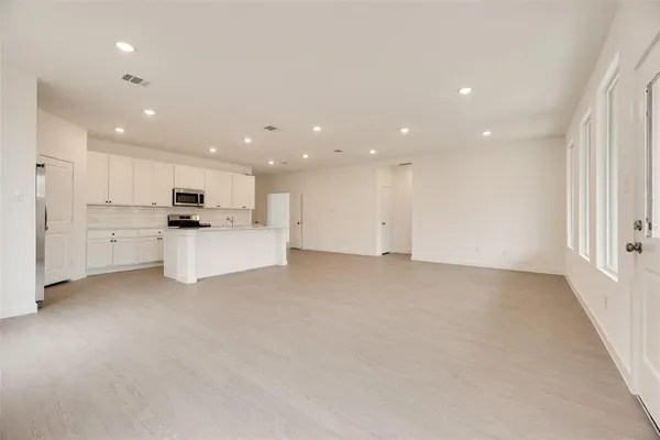 a view of kitchen with white cabinets and stainless steel appliances