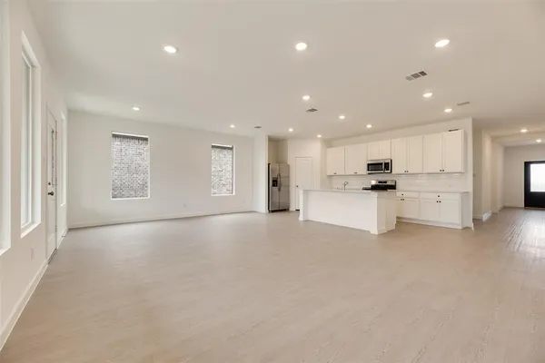 a view of an empty room with white cabinets