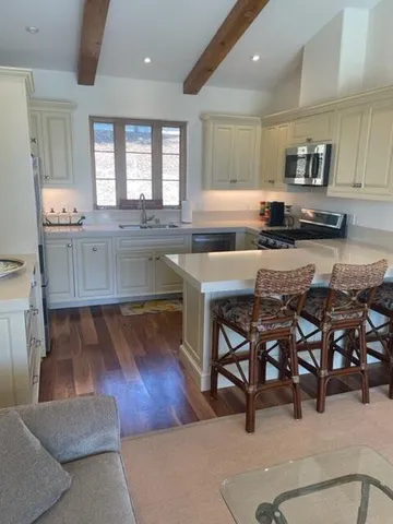 a kitchen with cabinets table and chairs