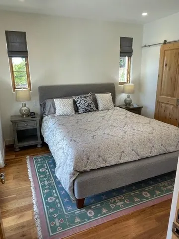 a bedroom with a bed and wooden floor