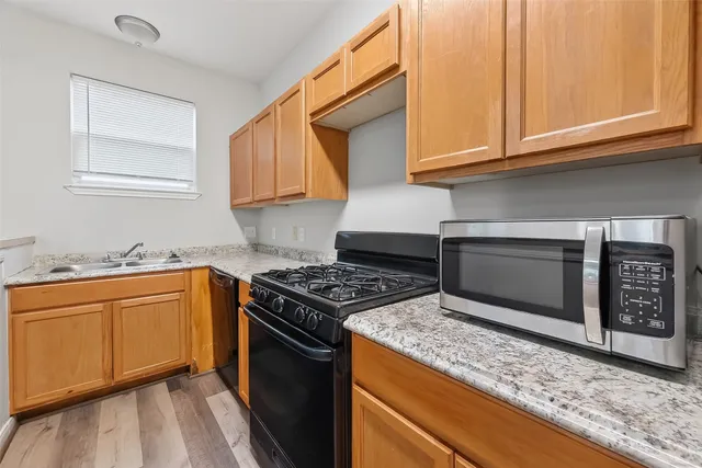 a kitchen with stainless steel appliances granite countertop a stove a sink and a microwave