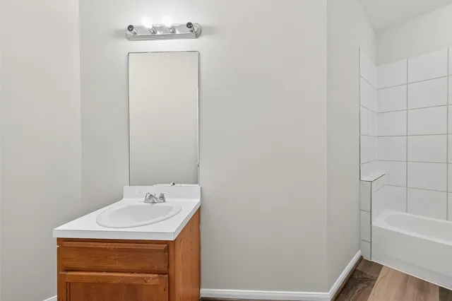 a bathroom with a sink a vanity and a bathtub