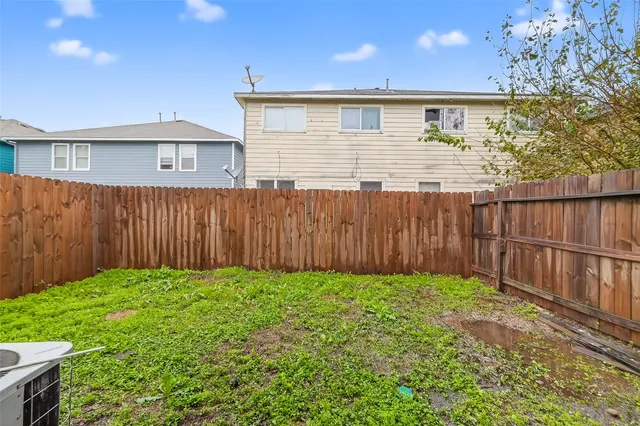 a view of a backyard with wooden fence