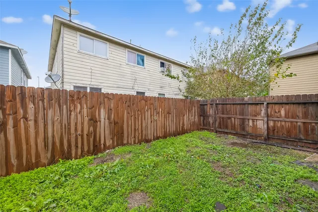 a view of backyard with wooden fence and trees