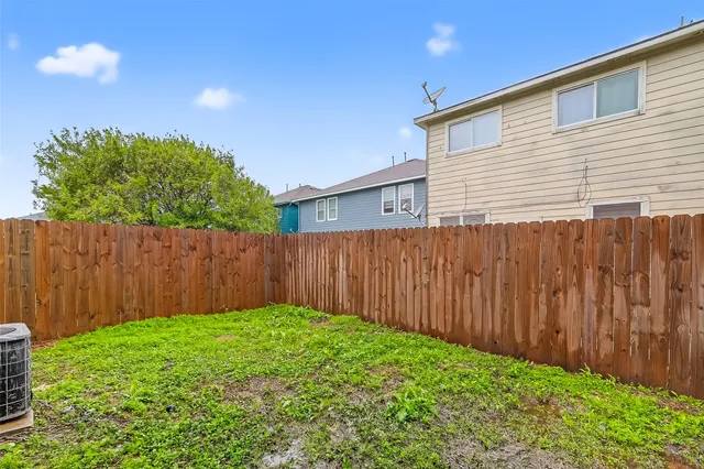 a view of a backyard with wooden fence