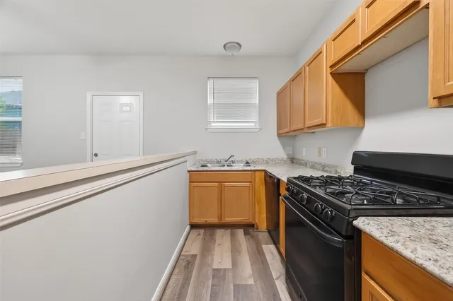 a kitchen with granite countertop a sink stove and cabinets