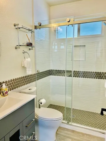 a bathroom with a sink a toilet and shower