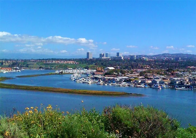 a view of a city with lots of residential buildings ocean and mountain view in back