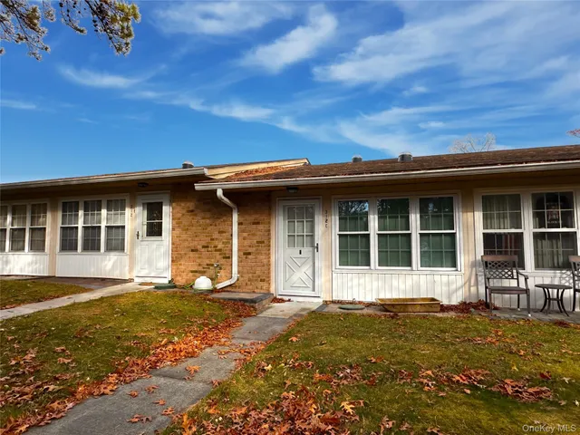 front view of a brick house with a yard