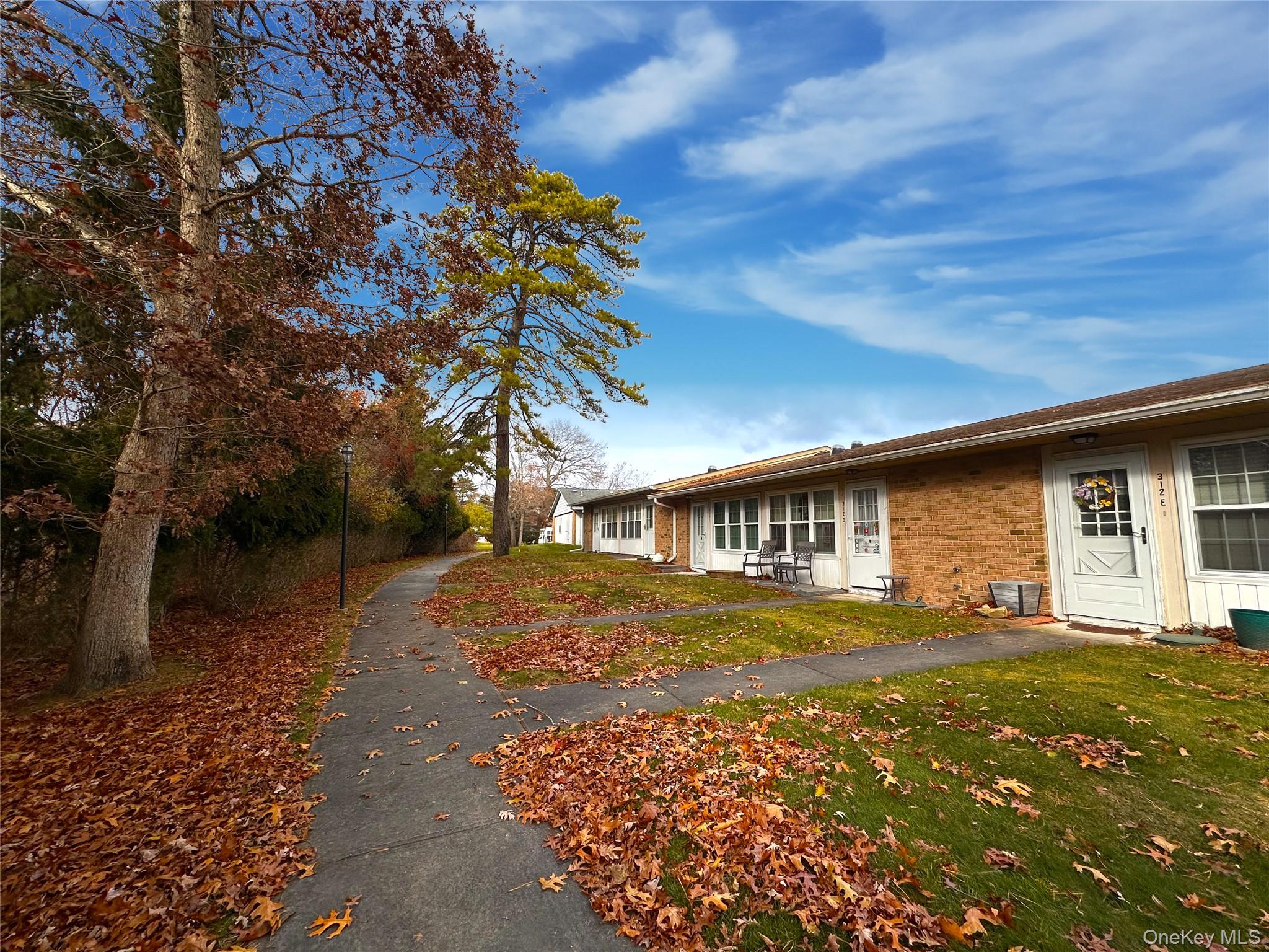 312 Woodbridge Drive, Unit C Ridge, NY 11961 - Photo 2 of 12 a front view of a house with a yard
