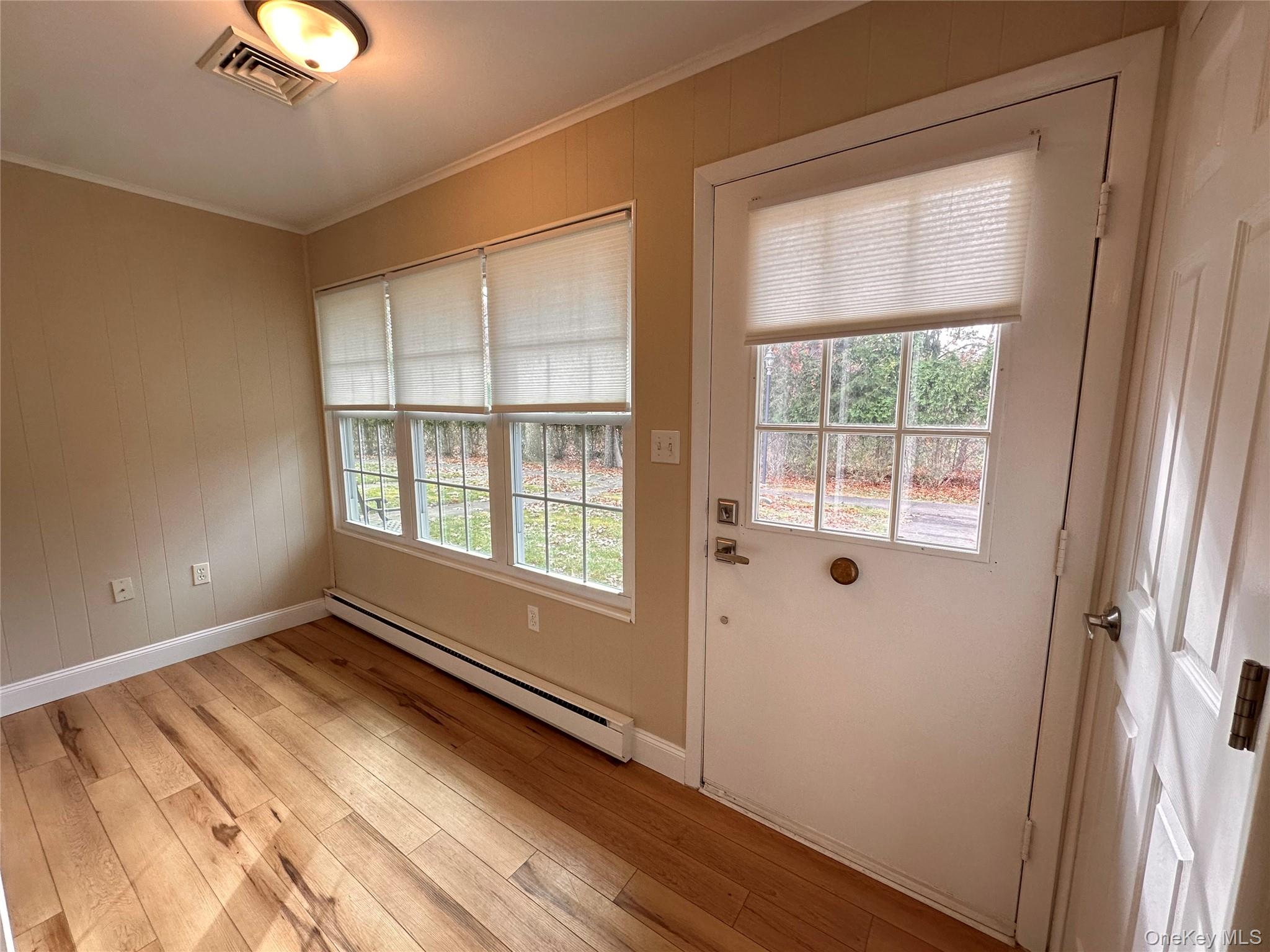 312 Woodbridge Drive, Unit C Ridge, NY 11961 - Photo 3 of 12 a view of an empty room with wooden floor and a window
