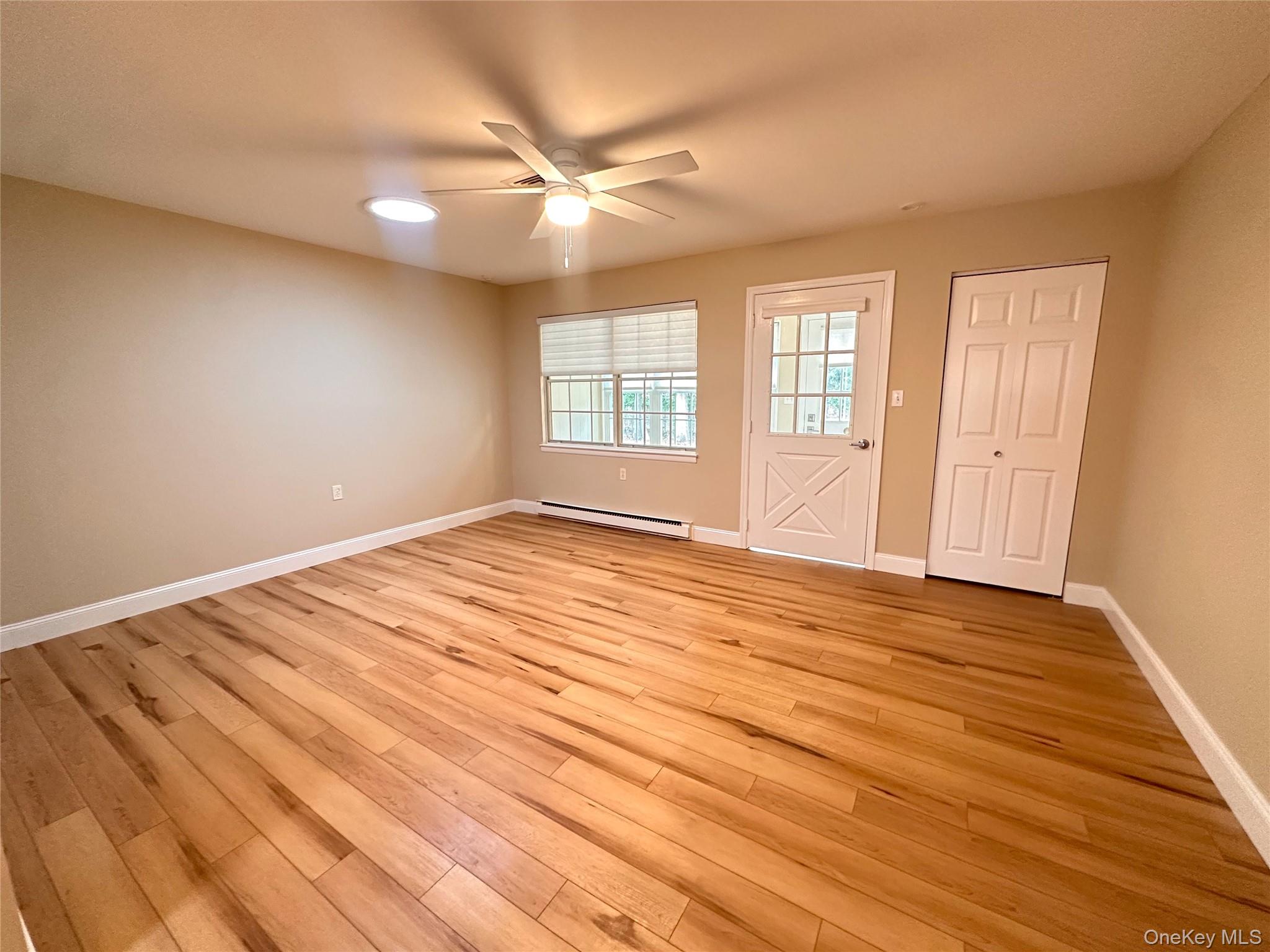 312 Woodbridge Drive, Unit C Ridge, NY 11961 - Photo 5 of 12 a view of empty room with wooden floor and fan