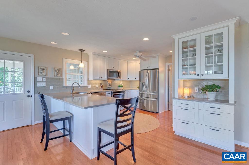 205 Old Stony Ridge Road Afton, VA 22920 - Photo 21 of 70 a kitchen with stainless steel appliances kitchen island granite countertop a refrigerator a stove a dining table and chairs with wooden floor