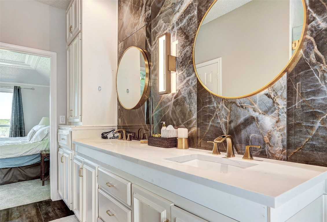 16 Tournament Way The Hills, TX 78738 - Photo 14 of 40 a bathroom with a double vanity sink and a mirror
