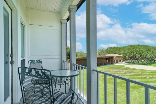 a view of a balcony with table and chairs