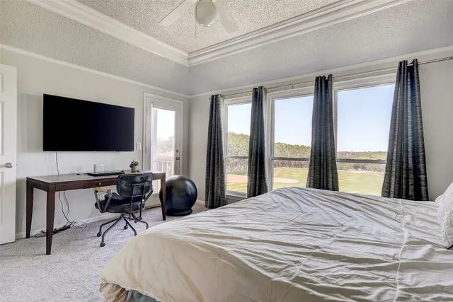 a bedroom with a bed window tv and a large window
