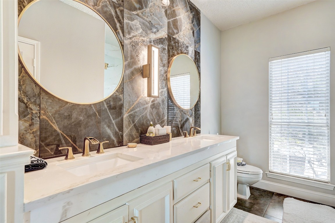 16 Tournament Way The Hills, TX 78738 - Photo 9 of 40 a bathroom with a sink mirror and a toilet