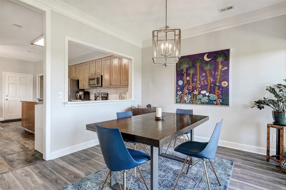 16 Tournament Way The Hills, TX 78738 - Photo 10 of 40 a view of a dining room with furniture wooden floor and a chandelier