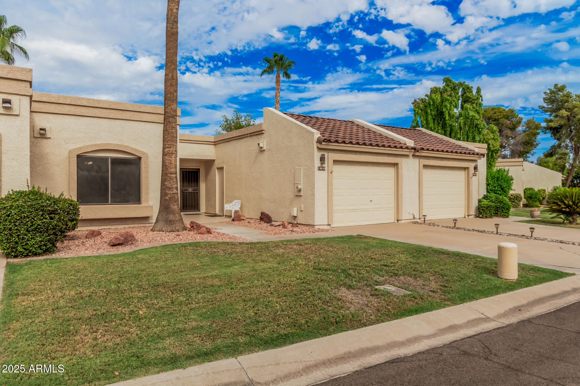 19095 North 97th Lane Peoria, AZ 85382 - Photo 1 of 36 a view of a white house with a yard potted plants and a table