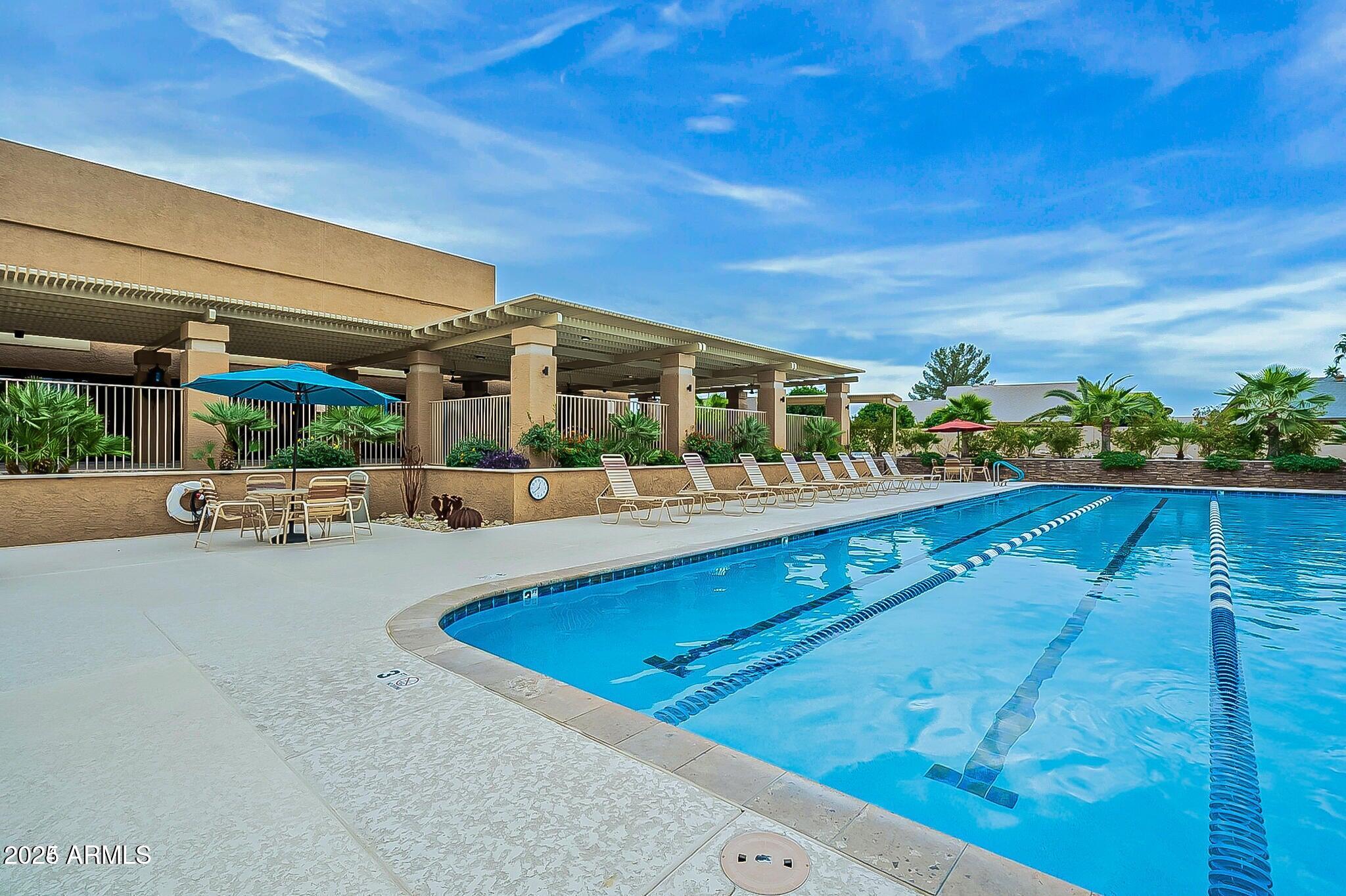 19095 North 97th Lane Peoria, AZ 85382 - Photo 14 of 36 a view of swimming pool with outdoor seating and a garden