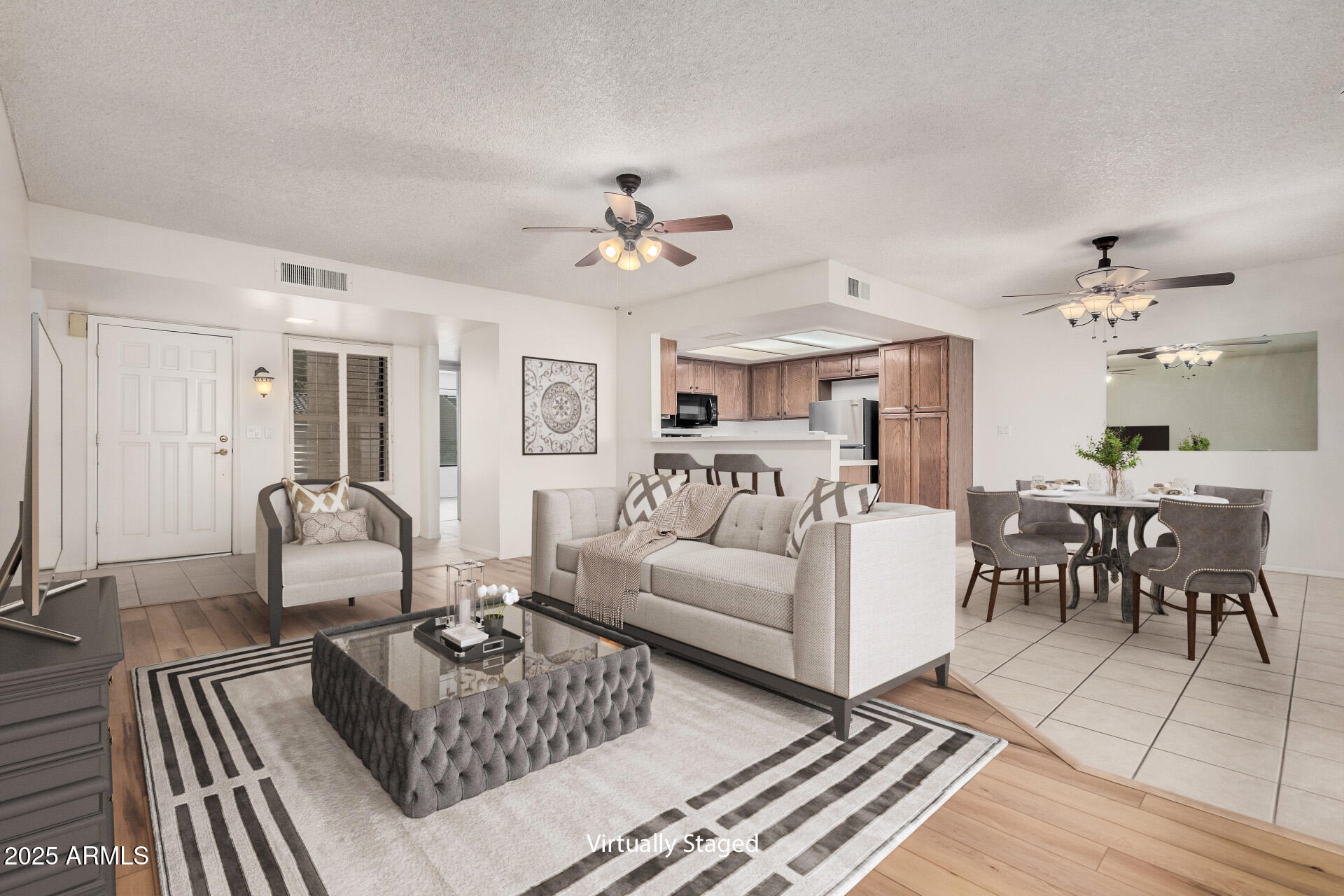 19095 North 97th Lane Peoria, AZ 85382 - Photo 3 of 36 a living room with furniture a rug and a chandelier