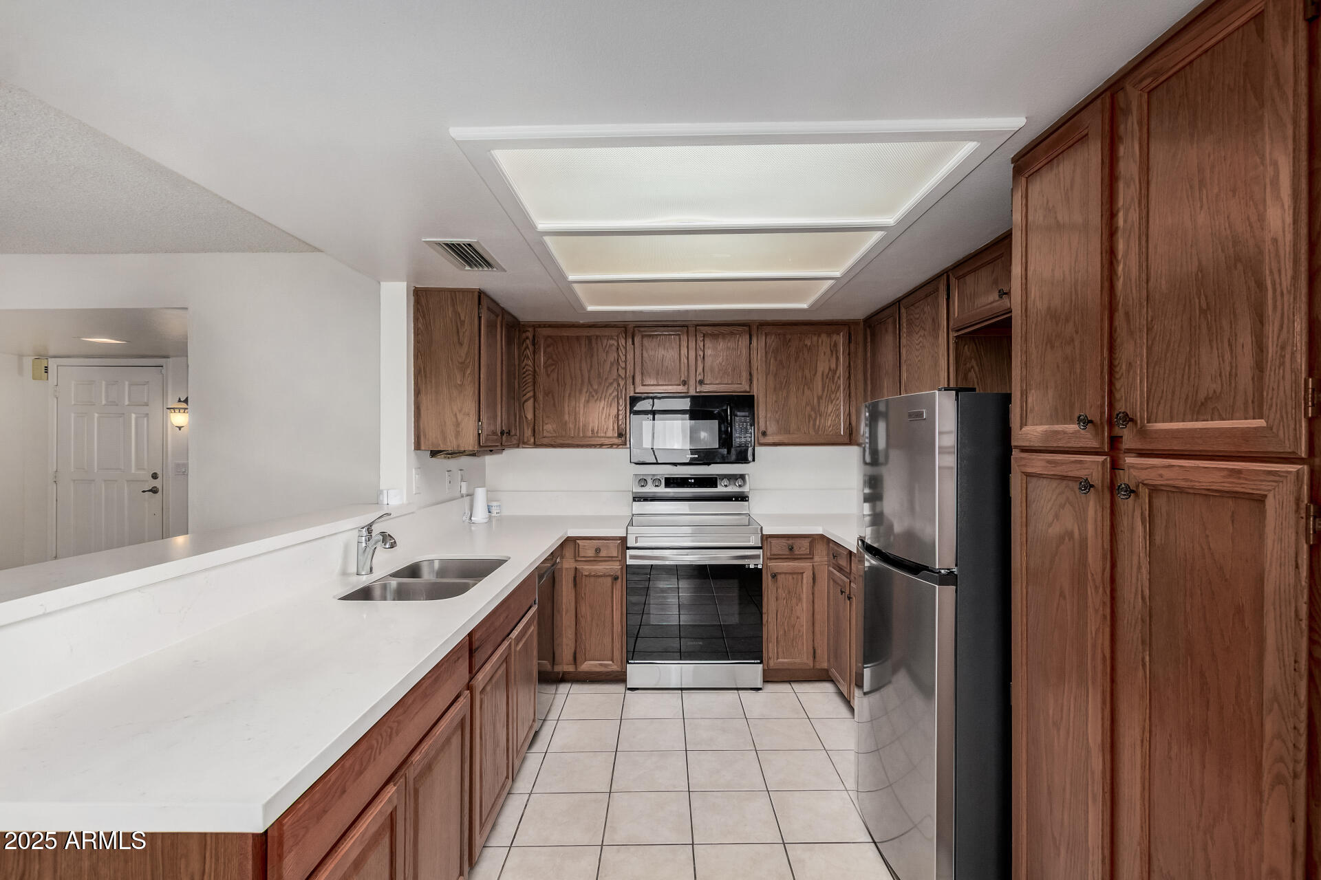 19095 North 97th Lane Peoria, AZ 85382 - Photo 4 of 36 a kitchen with stainless steel appliances granite countertop a sink stove and refrigerator