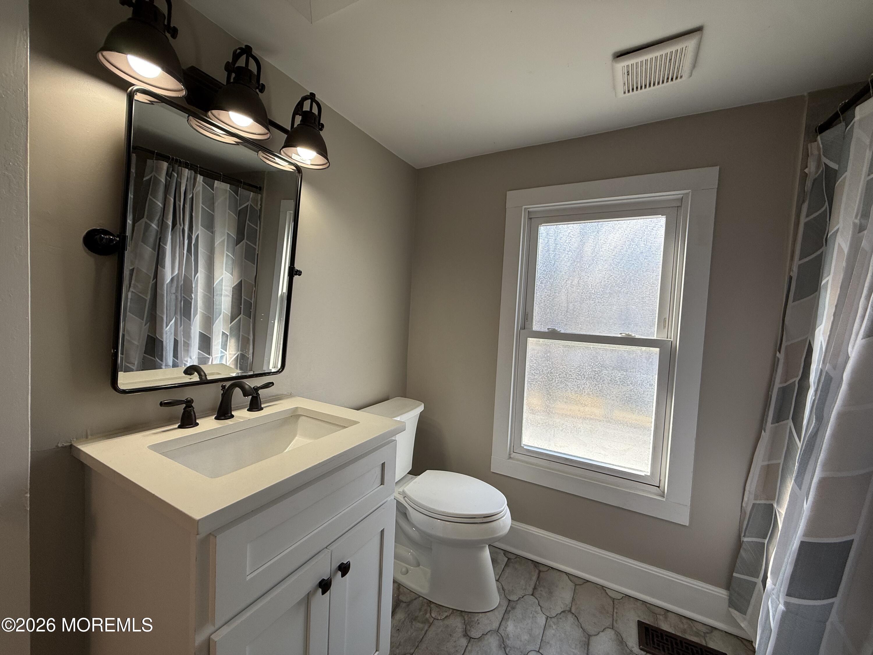 30 Conover Street Freehold, NJ 07728 - Photo 37 of 38 a bathroom with a toilet sink and mirror