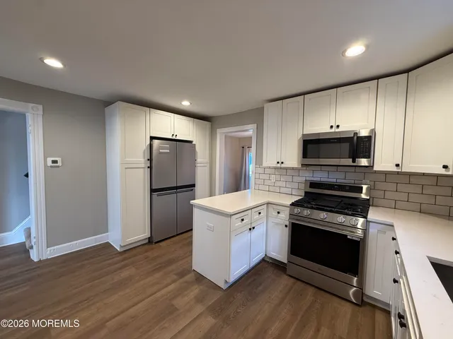 a kitchen with stainless steel appliances granite countertop a stove a refrigerator and a microwave