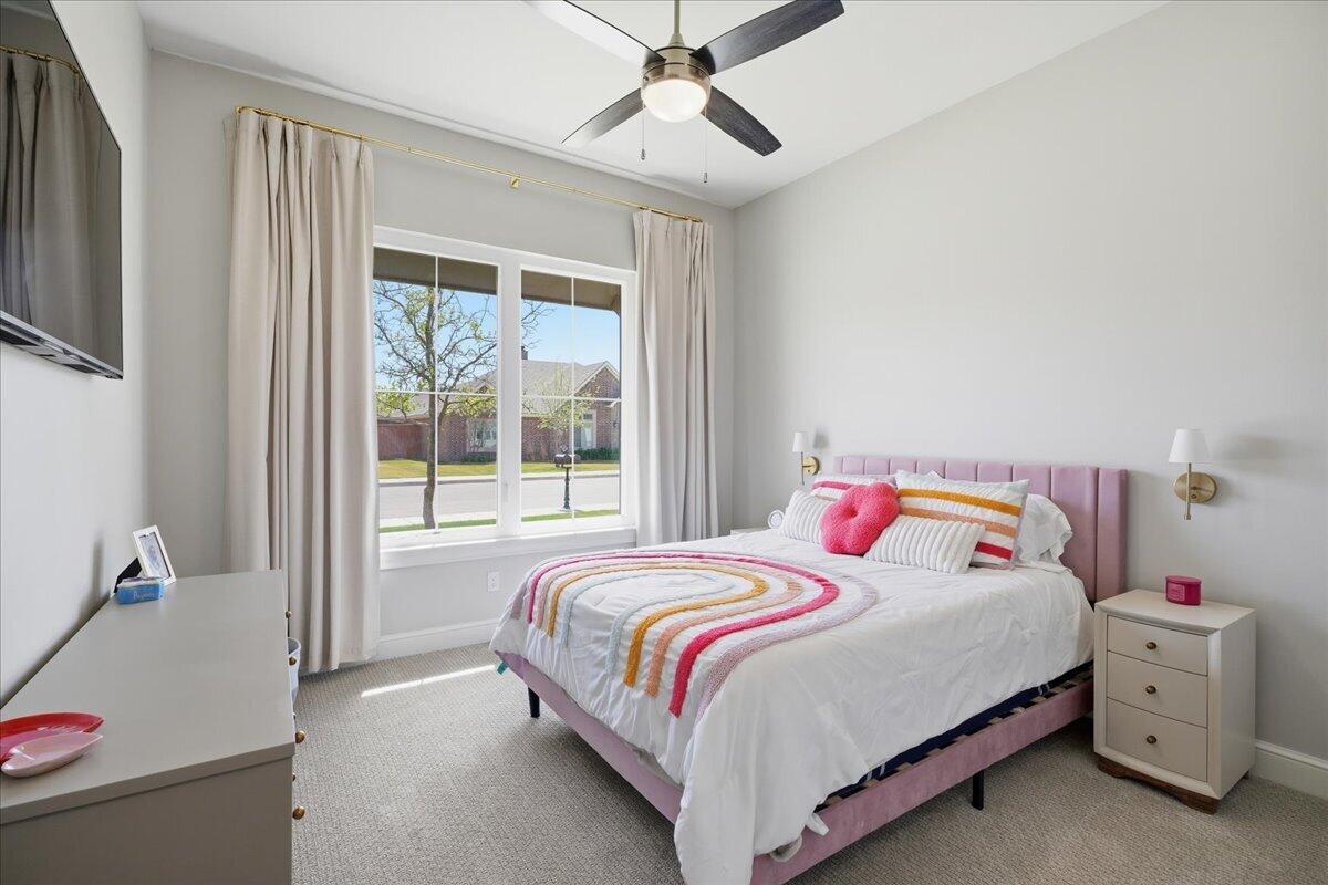4506 140th Street Lubbock, TX 79424 - Photo 39 of 62 a bedroom with a bed and a chandelier fan