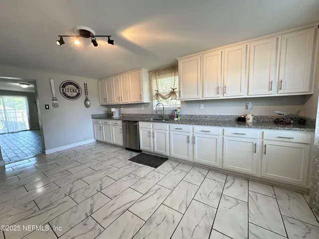 a kitchen with stainless steel appliances granite countertop a sink and cabinets