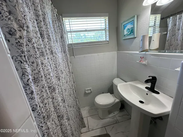 a bathroom with a sink toilet and a mirror