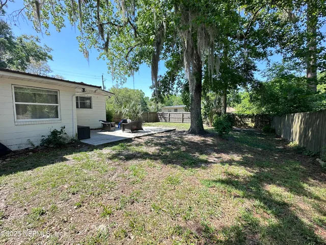 a backyard of a house with table and chairs