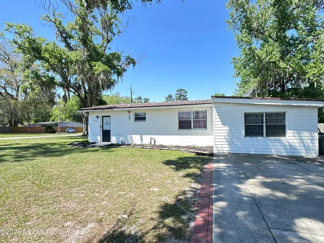 a view of a yard with a house and a tree