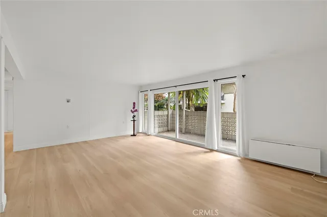 a kitchen with stainless steel appliances a refrigerator and a wooden floor