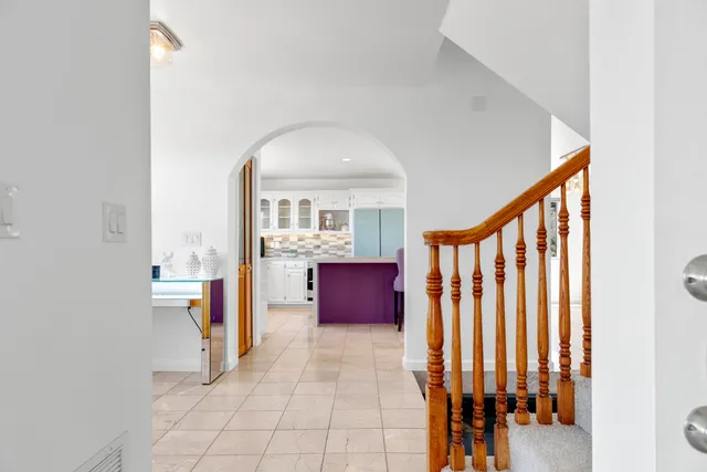 a kitchen with stainless steel appliances kitchen island granite countertop a stove a sink a refrigerator and chairs