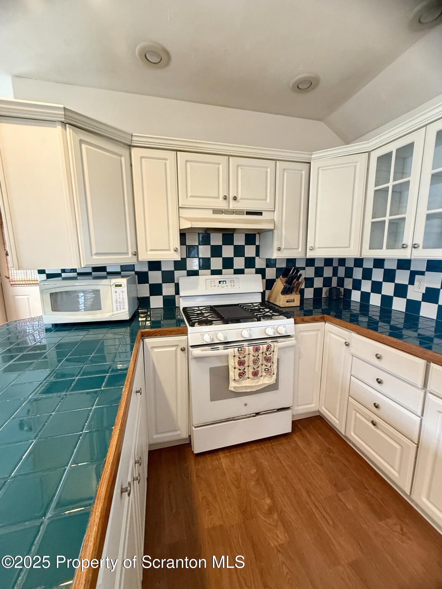 302 Main Street Blakely, PA 18452 - Photo 23 of 38 a kitchen with kitchen island granite countertop white cabinets and white appliances