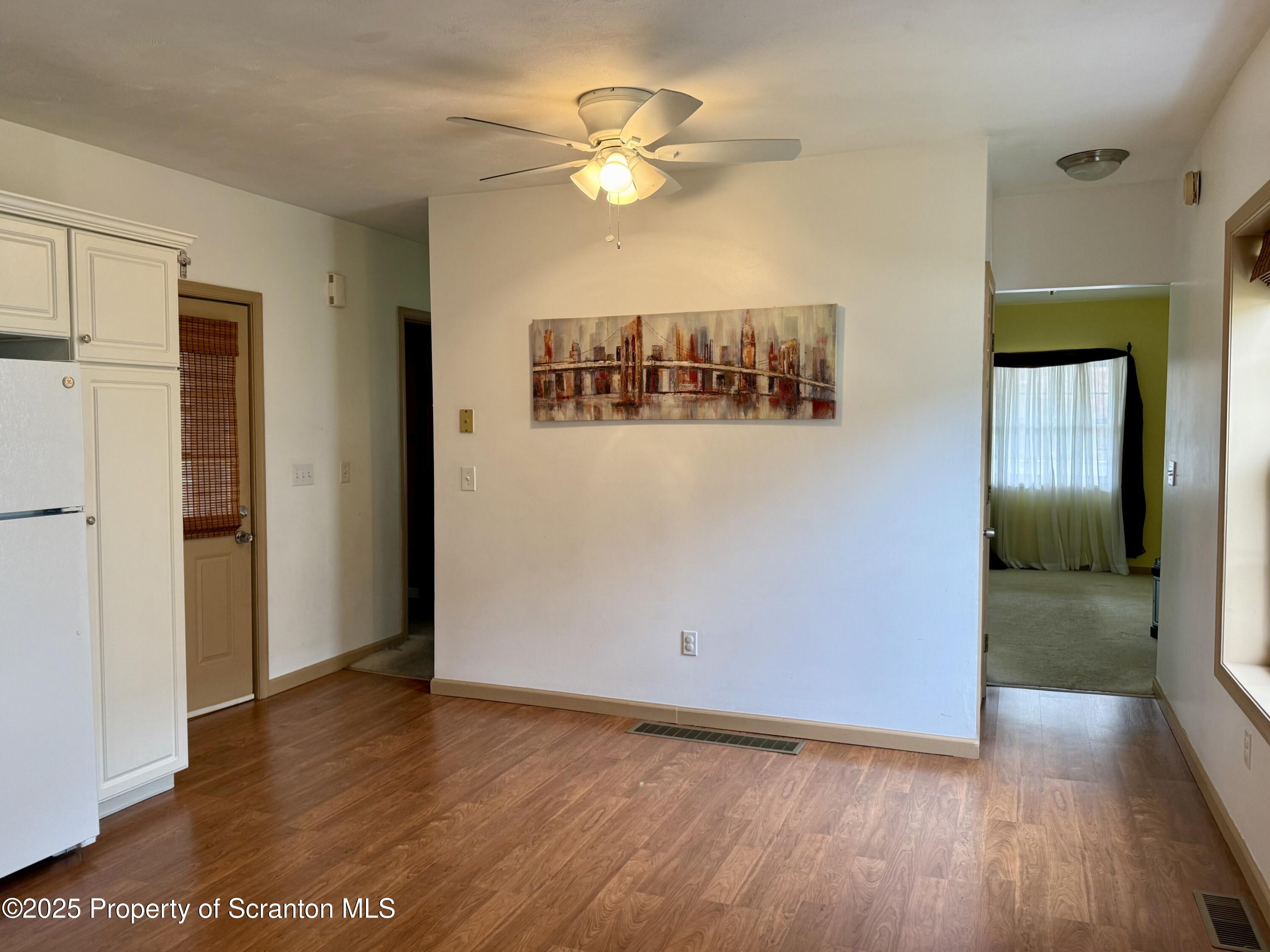 302 Main Street Blakely, PA 18452 - Photo 25 of 38 a view of an empty room with wooden floor and a ceiling fan