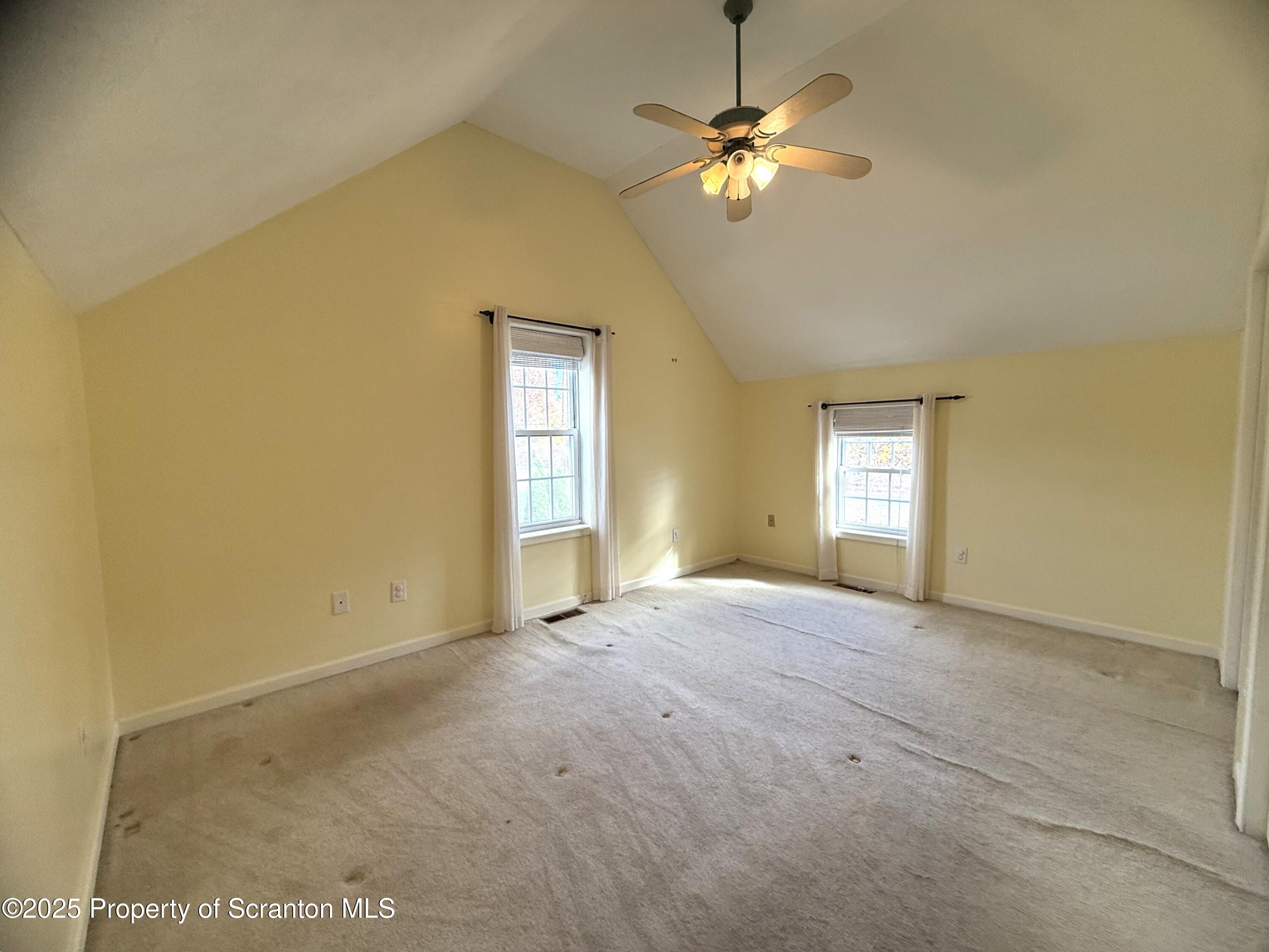 302 Main Street Blakely, PA 18452 - Photo 32 of 38 an empty room with a chandelier fan and windows