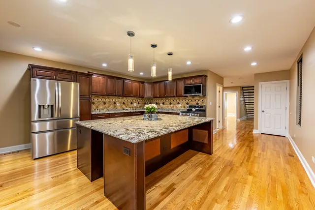 a kitchen with stainless steel appliances granite countertop a refrigerator and a stove